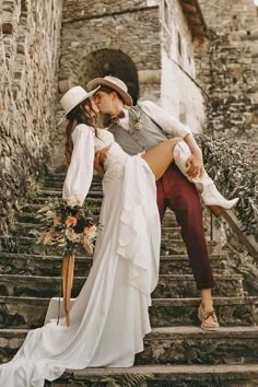 a bride and groom are kissing on the stairs