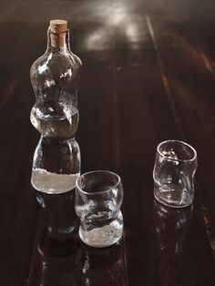 an empty bottle and two glasses on a wooden table