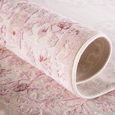 a close up view of a pink and white rug on a bed with no sheets