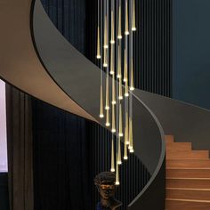 a modern chandelier hanging from the side of a spiral staircase