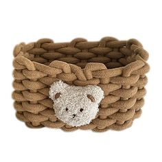 a teddy bear in a woven basket on a white background