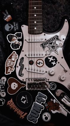 an electric guitar with many stickers on it