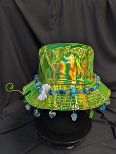 -hat color - green -bead color - blue -charm color - blue -unisex adult size -inner circumference - 22.5in -crown dip - 3in -brim - 2.25in -NOT machine washable -Perfect for raves and outdoor festivals! Shipping within the US USPS First Class Package 3-9 days USPS Priority Mail 1-5 days USPS Priority Mail Express 1-3 days Shipping International  USPS First Class Mail International  -Varies- USPS Priority Mail International 6-14 days USPS Priority Mail Express International 3-9 days Shipping times are estimated, NOT GUARENTEED.  +International buyers are responsible for all import fees+ +Orders of $50+ may require signature confirmation upon delivery+ Blue Bucket Hat With Short Brim For Festivals, Blue Bucket Hat With Curved Brim For Festivals, Blue Short Brim Bucket Hat For Festivals, Blue Curved Brim Bucket Hat For Festival, Adjustable Green Costume Hats With Short Brim, Blue Brimmed Bucket Hat For Festival, Adjustable Green Hat For Festival, Adjustable Green Hats For Festivals, Adjustable Green Hat For Festivals