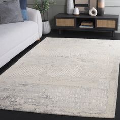 a living room area with a couch, coffee table and white rug on the floor