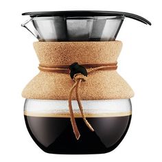 a coffee pot filled with liquid and topped with a brown ribbon tied around the bottom