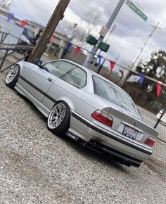 a silver car parked on top of a gravel road