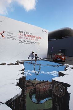 a man and woman standing on top of a giant painting