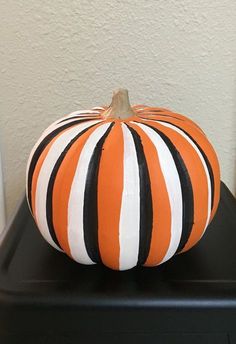 a striped pumpkin sitting on top of a black table