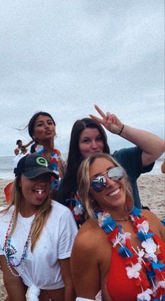 three women standing on the beach posing for a photo