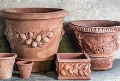 several clay pots and planters sitting on a ledge