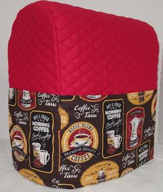 a red and black quilted pot holder with coffee related images on the front, sitting on a white surface