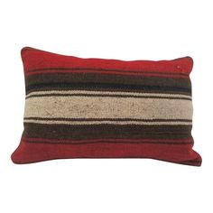 a red and brown striped pillow on a white background