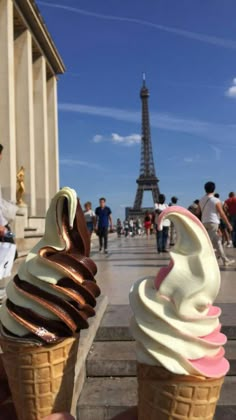 two ice cream cones in front of the eiffel tower