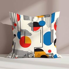 a colorful pillow on a white bed