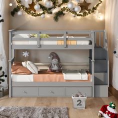 there is a bunk bed with drawers underneath it and christmas decorations on the wall above