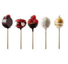 four different types of desserts on wooden sticks