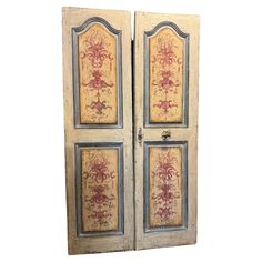 an old wooden door with floral designs painted on the front and side doors, both closed