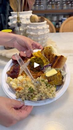 two hands holding a plate with food on it and another hand reaching for the plate