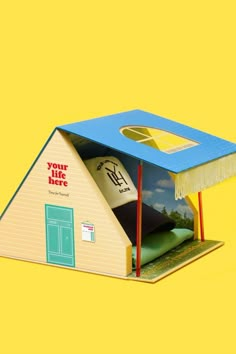 a paper model of a house with a surfboard in it's roof and the door open