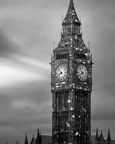 the big ben clock tower towering over the city of london at night with lights on it