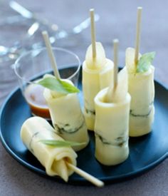 small appetizers with toothpicks on a black plate