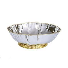 a silver bowl with gold trimmings on the rim and bottom, sitting in front of a white background