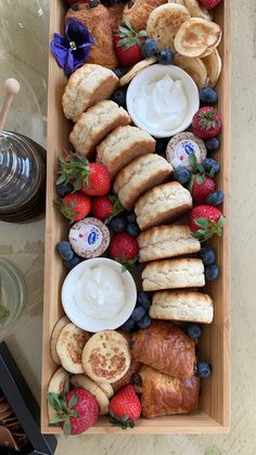 a wooden tray filled with pastries and fruit