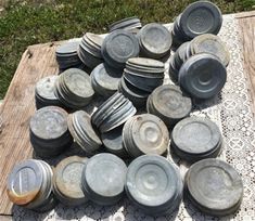 a pile of metal pots and pans sitting on top of a doily covered table