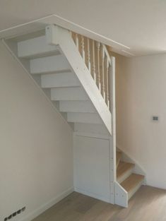 an empty room with stairs leading up to the second floor and another door on the other side