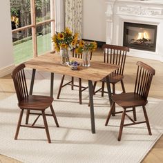 a dining table with four chairs and a fire place in the backround area