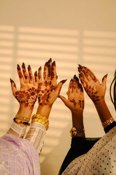 two women are holding their hands up to show off their hendigns and nails