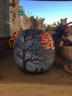 two painted pumpkins sitting on top of a table next to baskets and other items