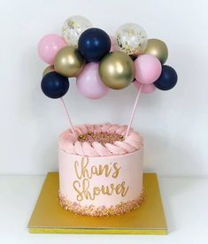 a pink and gold cake with balloons on top that say hank's showerer