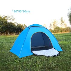 a blue tent sitting on top of a lush green field