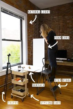 a woman standing in front of a window next to a whiteboard and easel