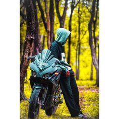 a person in a hooded jacket sitting on a motorcycle