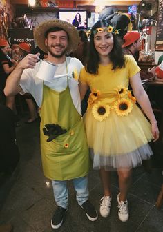 a man and woman dressed up in costumes at a restaurant, posing for the camera