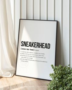 there is a sign that says sneakerhead next to a potted plant on the floor