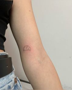 a woman's arm with a small elephant tattoo on the left side of her arm