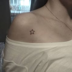 a woman with a small star tattoo on her chest