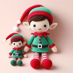 two crocheted elf dolls are posed next to each other on a pink background