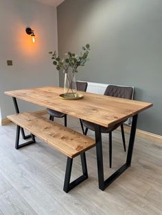 a wooden table with two benches next to it on a hard wood floored floor