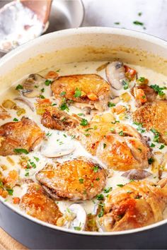 a pan filled with chicken and mushrooms covered in gravy