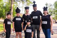 a group of people standing next to each other wearing black tshirts and crowns