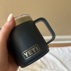 a person holding a yeti coffee mug in their hand