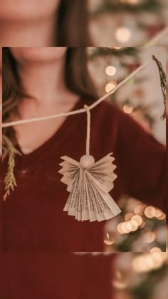 a woman wearing a red shirt holding a christmas ornament