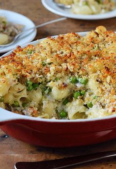 a casserole dish filled with macaroni and cheese on a wooden table