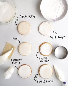 the ingredients to make sugar cookies laid out on a white counter top, including frosting and piping