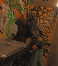 a man and woman kissing in a public restroom