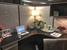 an office desk with a laptop computer on top of it next to a flower vase